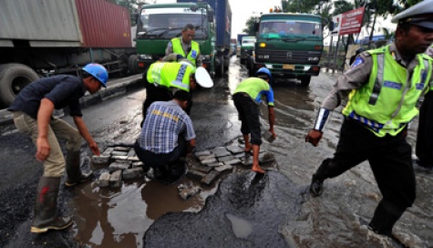 polisi perbaiki jalan rusak