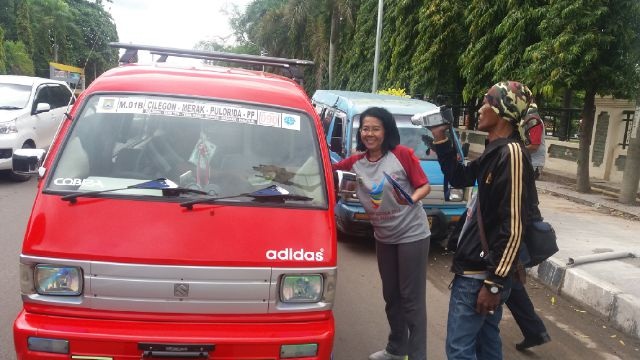 Kepala Dinas Kesehatan, dr Arriadna Saat Membagikan Stiker Kepada Sopir Angkot Dalam Peringatan Hari AIDS Sedunia. (Foto, Ist)