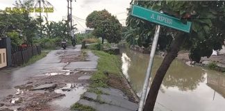 Kondisi jalan inspeksi Kadipaten Cilegon yang rusak parah dan berlubang