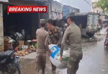 Tiga anggota Satpol PP mengangkut karung milik pedagang kaki lima saat penertiban di area pintu masuk Pasar Kranggot, Cilegon.