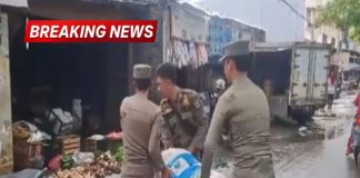 Tiga anggota Satpol PP mengangkut karung milik pedagang kaki lima saat penertiban di area pintu masuk Pasar Kranggot, Cilegon.